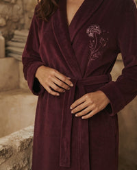 Détail de la broderie de pissenlit et de la ceinture nouée sur le velours de coton violet prune, peignoir femme Heure Sauvage