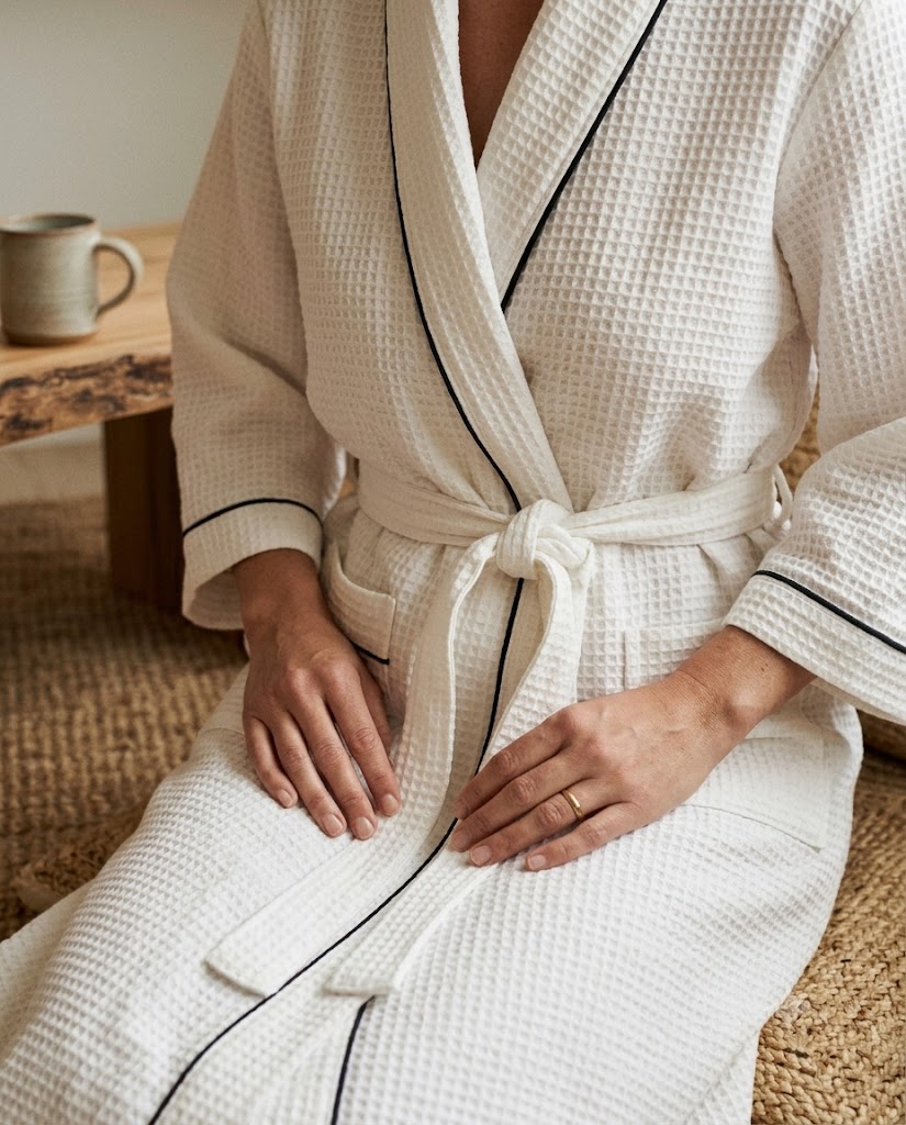 Gros plan tissage nid d'abeille blanc liseré noir, mains sur ceinture